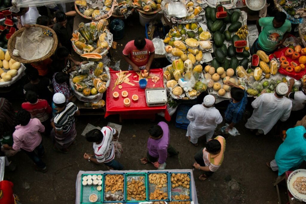a group of people standing around a table filled with food